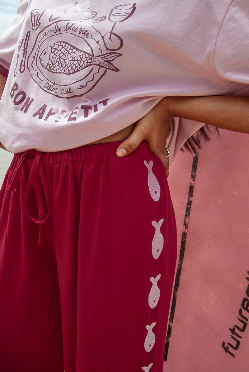 Deep red pants from Palm Collective with embroidered fish down the sides.