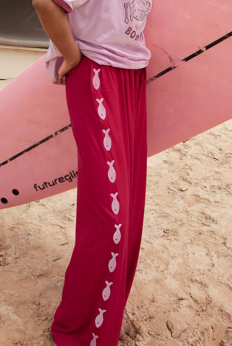 Deep red pants from Palm Collective with embroidered fish down the sides.
