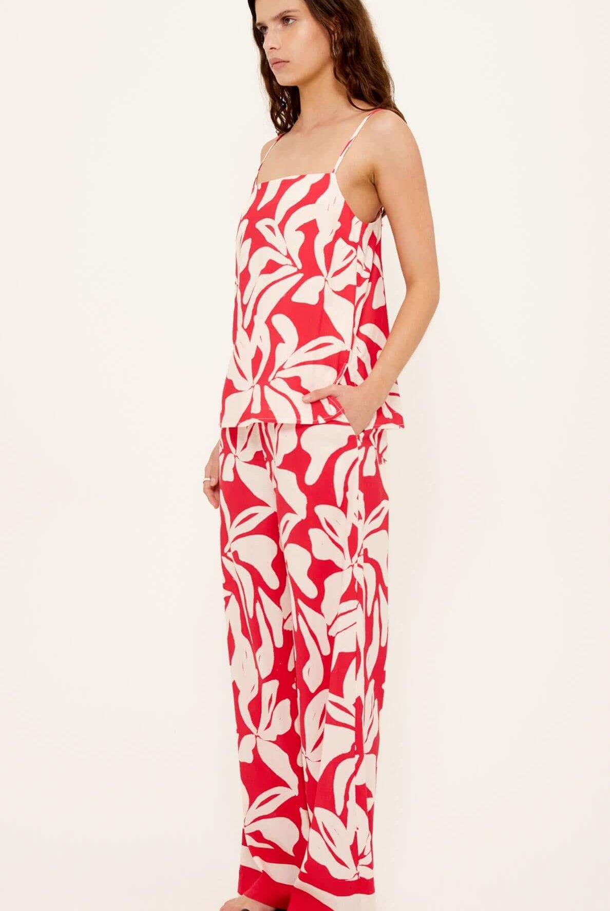 Woman wearing a red and white floral dress on a white background