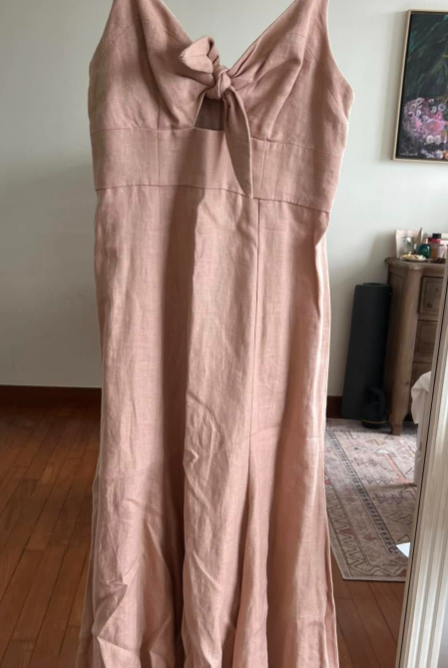 Pink dress hanging on a hanger in front of a mirror