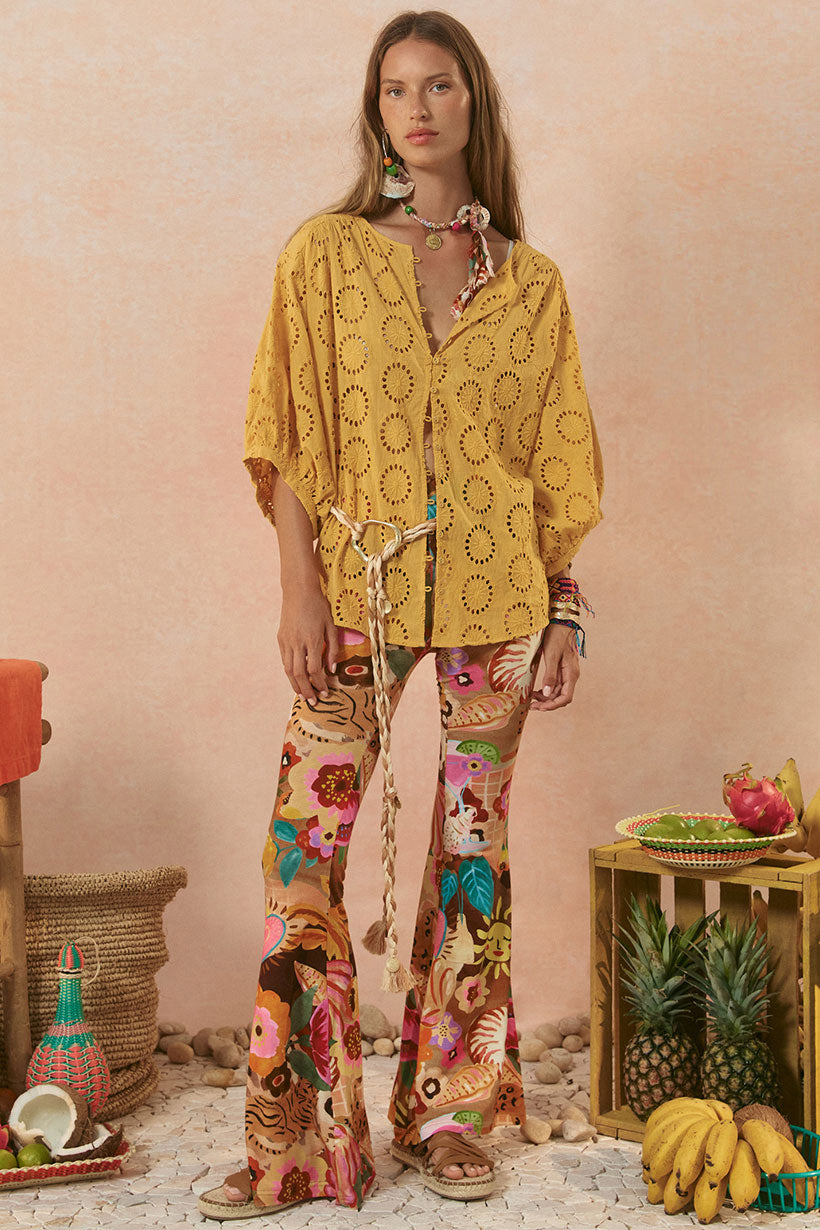 Woman wearing a yellow patterned outfit with a colorful background