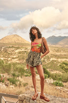 Woman standing outdoors with mountains and greenery in the background