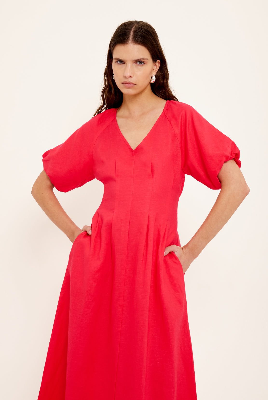 Woman wearing a red dress against a plain background