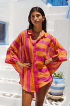 Woman wearing a colorful striped shirt in a Mediterranean setting
