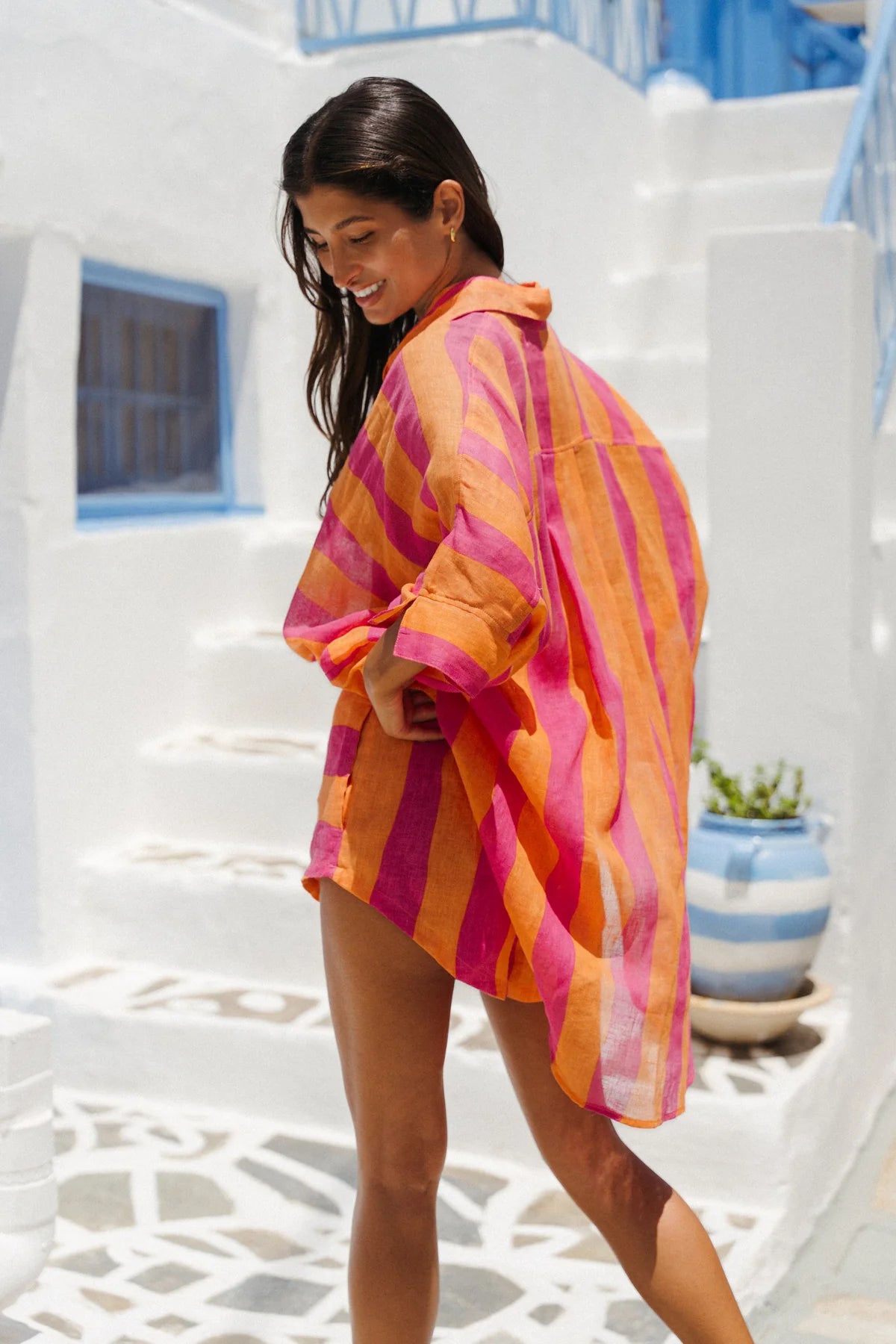 Woman wearing a colorful striped shirt in a white architectural setting
