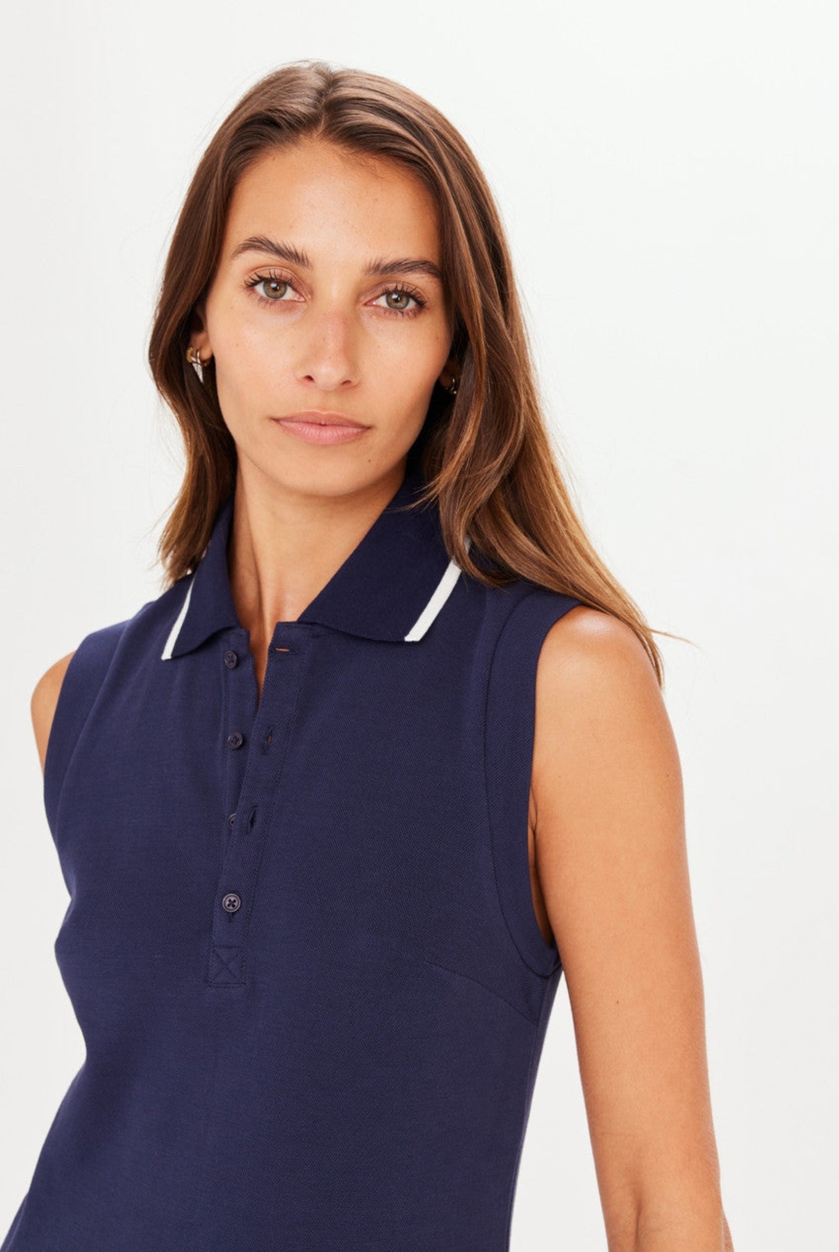 Navy blue tennis dress with button through and stand collar featuring a pleated skirt