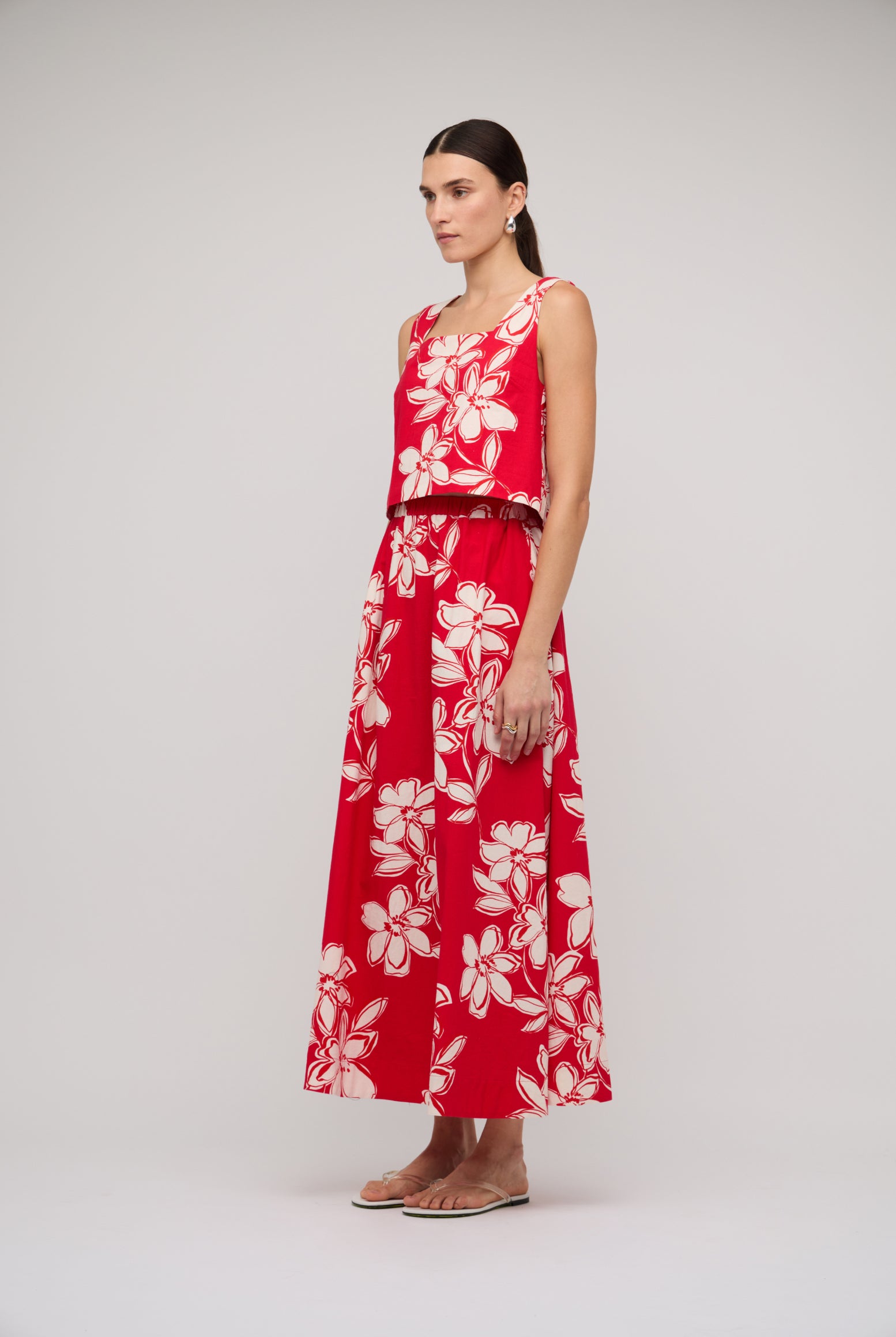 Woman wearing a red floral dress on a white background