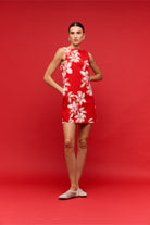 Woman wearing a red floral dress on a red background