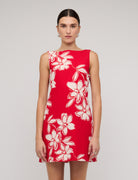 Red dress with white floral pattern worn by a model on a plain background