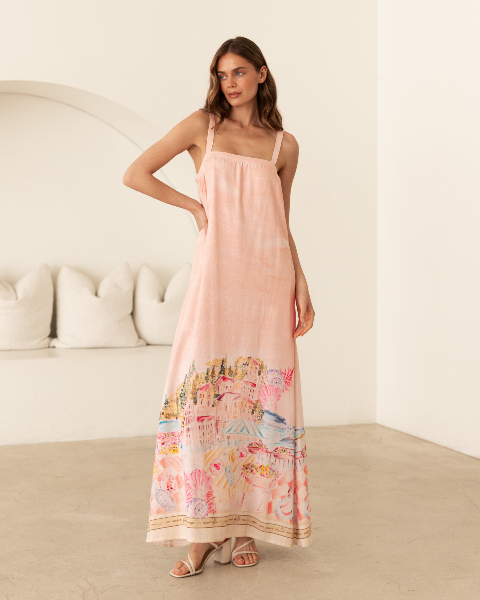 Ebby and I Luciana Maxi Dress worn by model on a white background. Coral placement print maxi with adjustable straps.