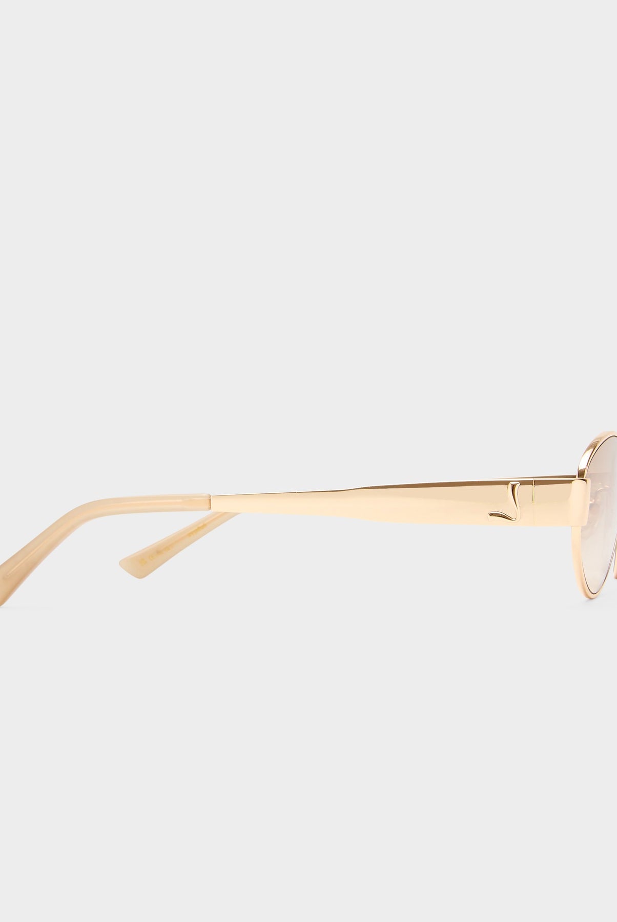 Gold-framed sunglasses on a light gray background