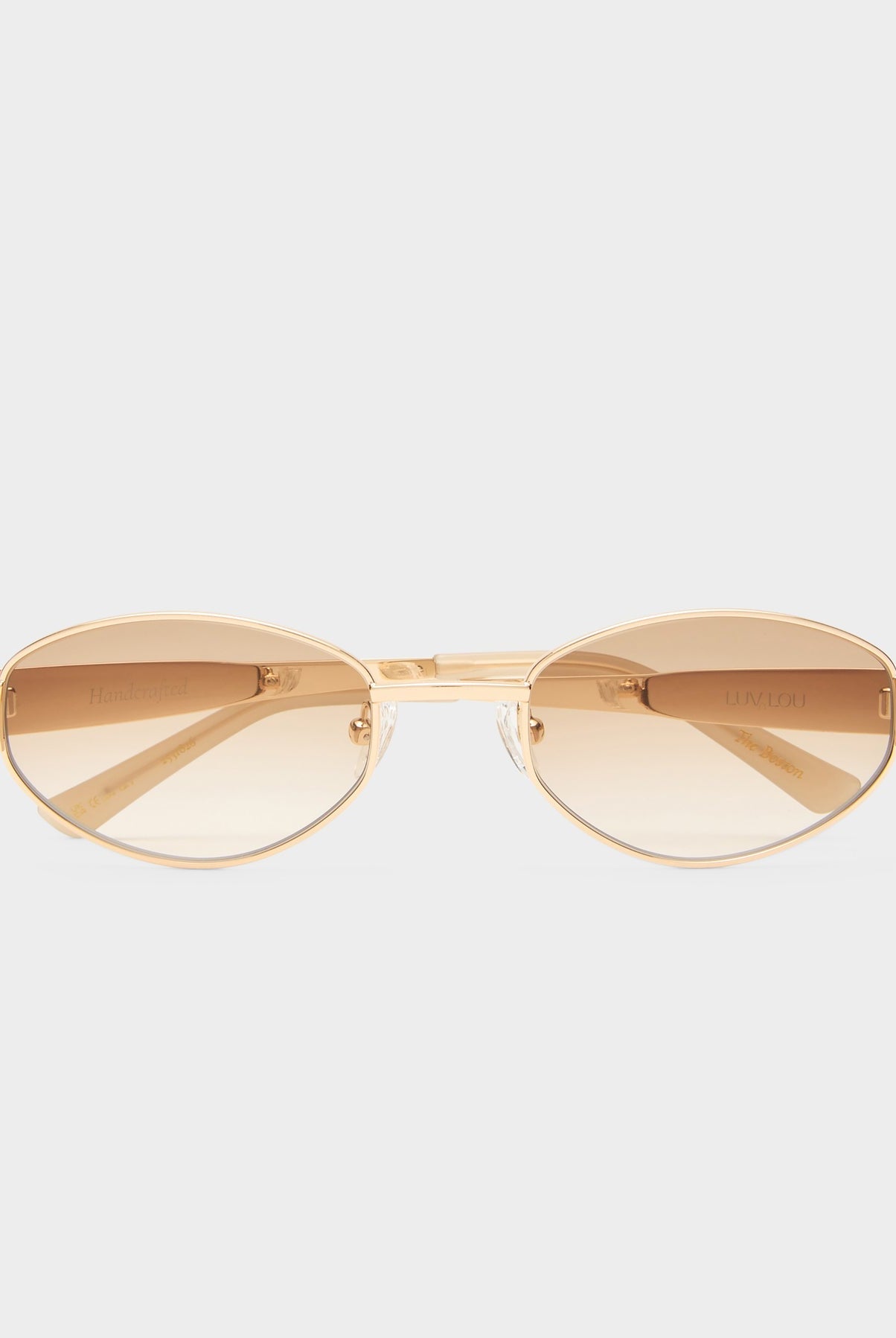 Gold sunglasses with a reflective surface on a white background
