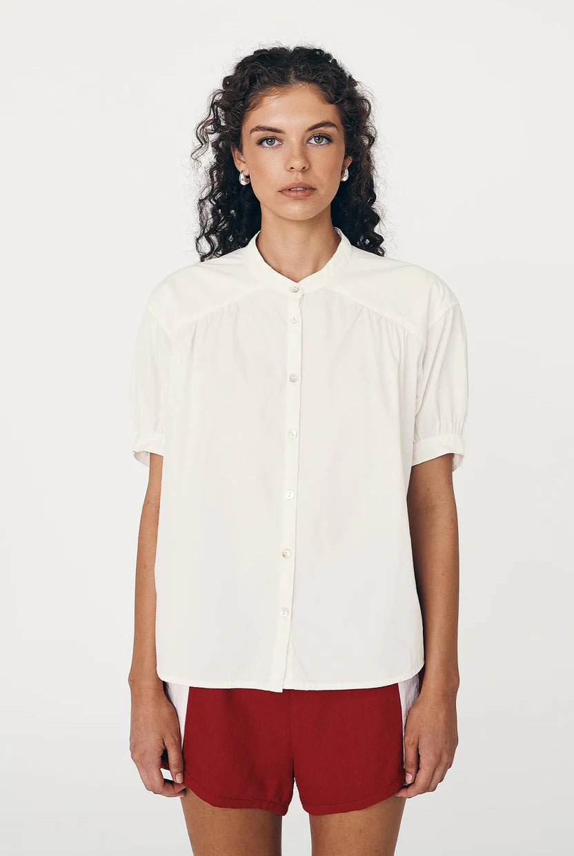 Woman wearing a white shirt and red shorts on a white background