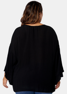 Woman wearing black boho blouse from the back