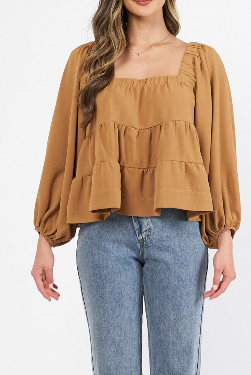 Woman wearing cinnamon colour trapeze top