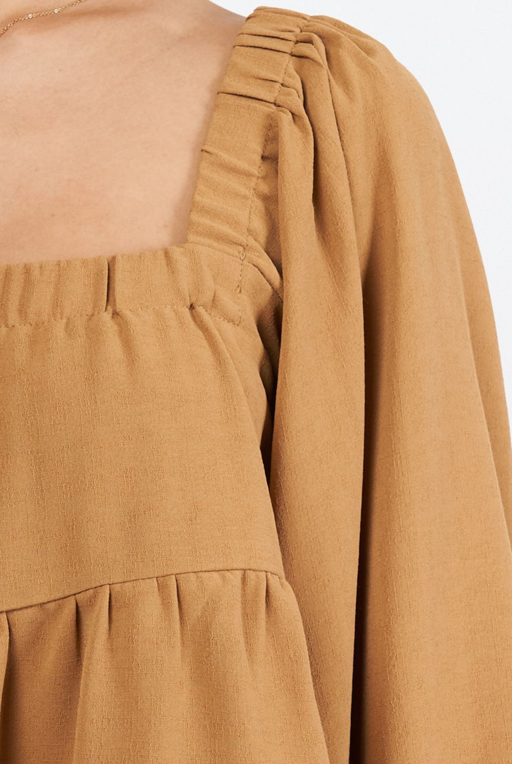 Woman wearing cinnamon colour trapeze top