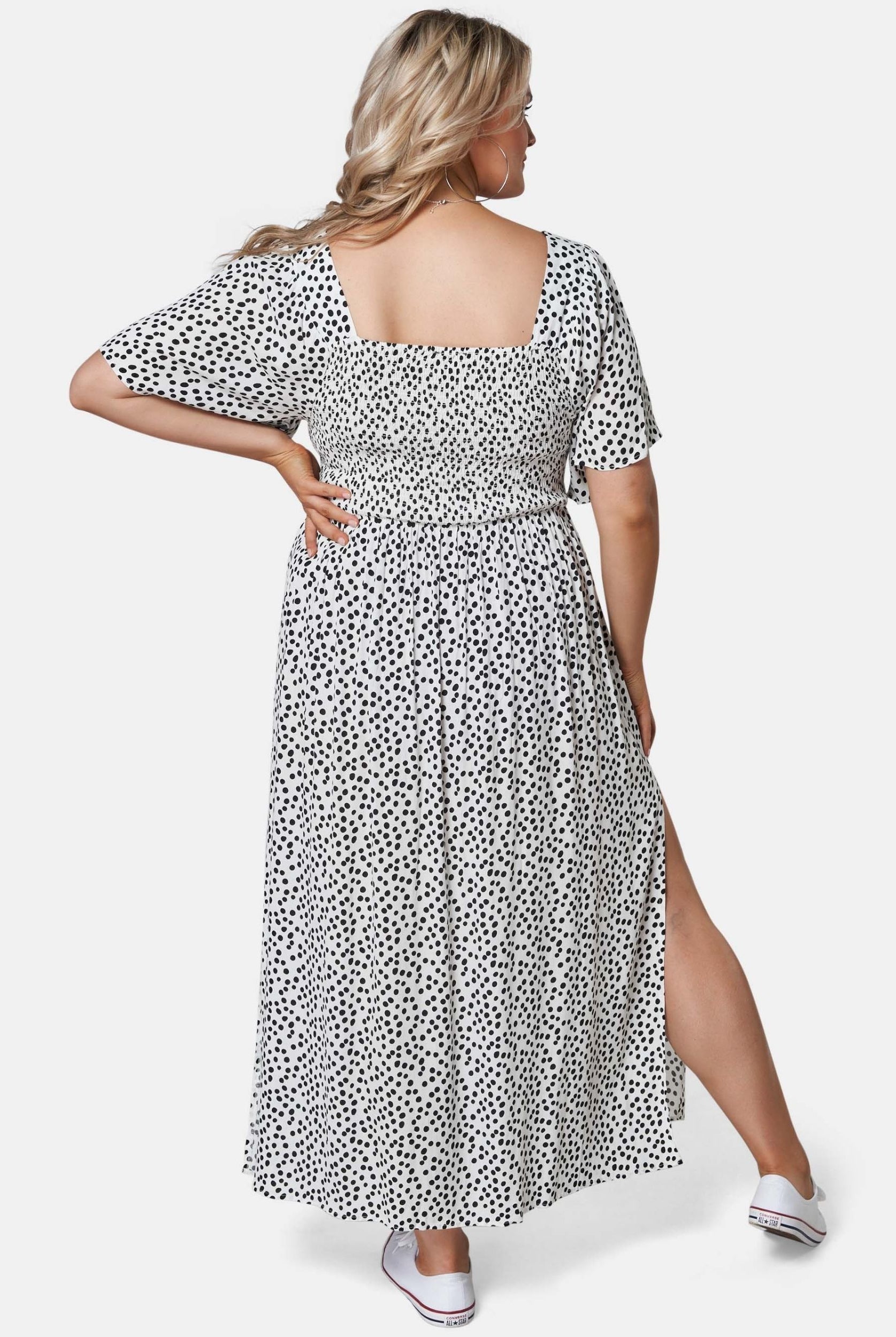 Blonde woman wearing black and white spot maxi dress