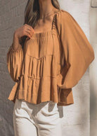 Woman wearing cinnamon colour trapeze top