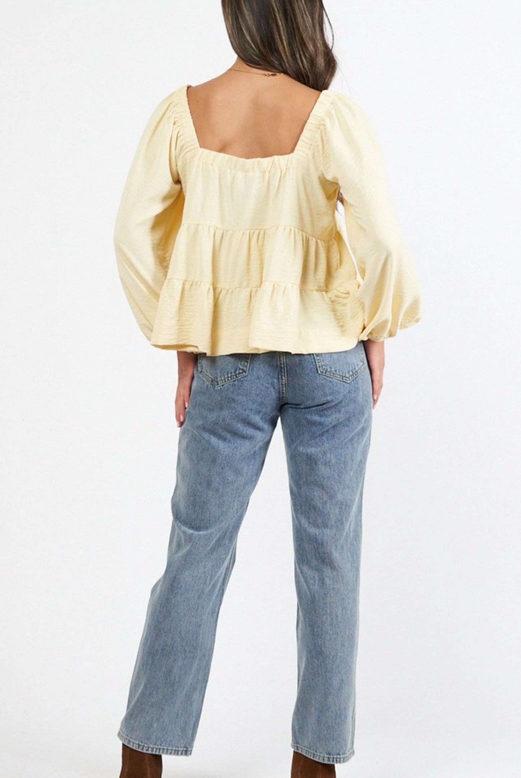 Model wearing a yellow top from the back