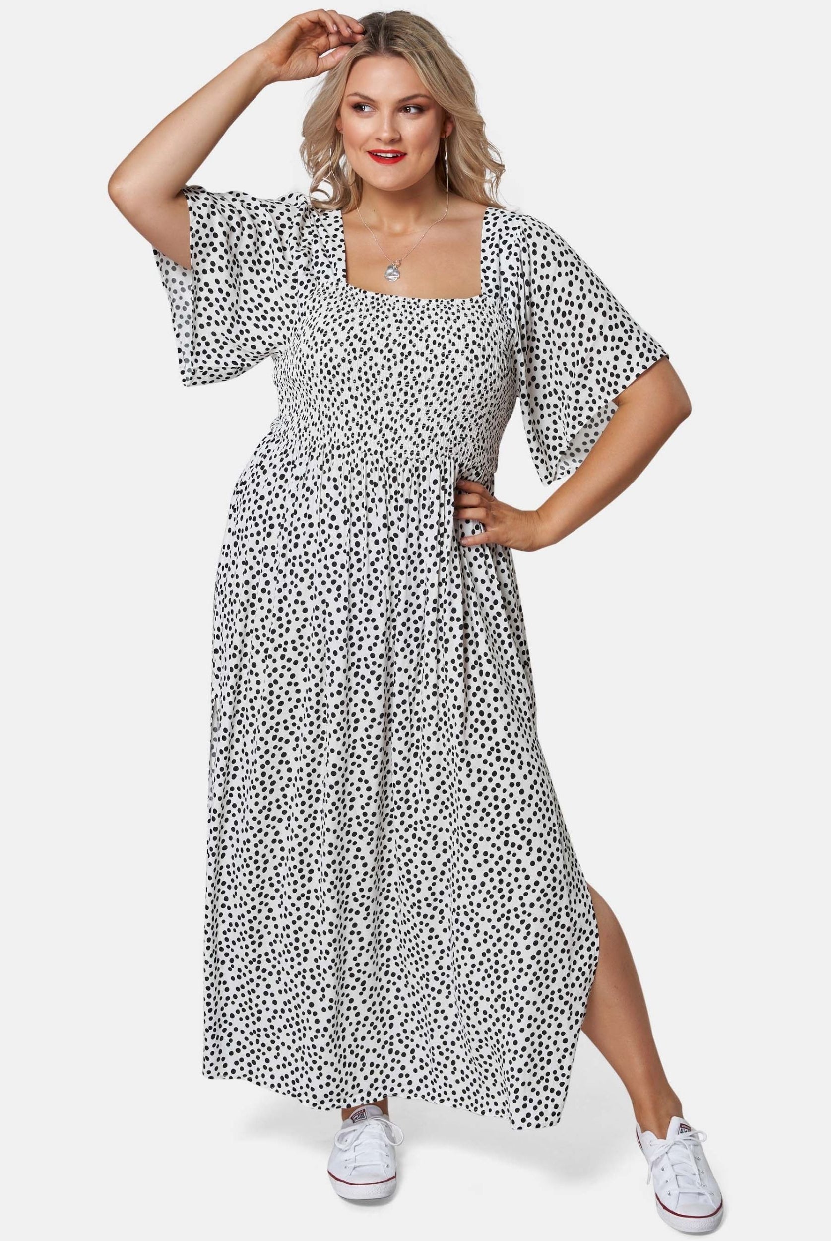 Blonde woman wearing black and white spot maxi dress