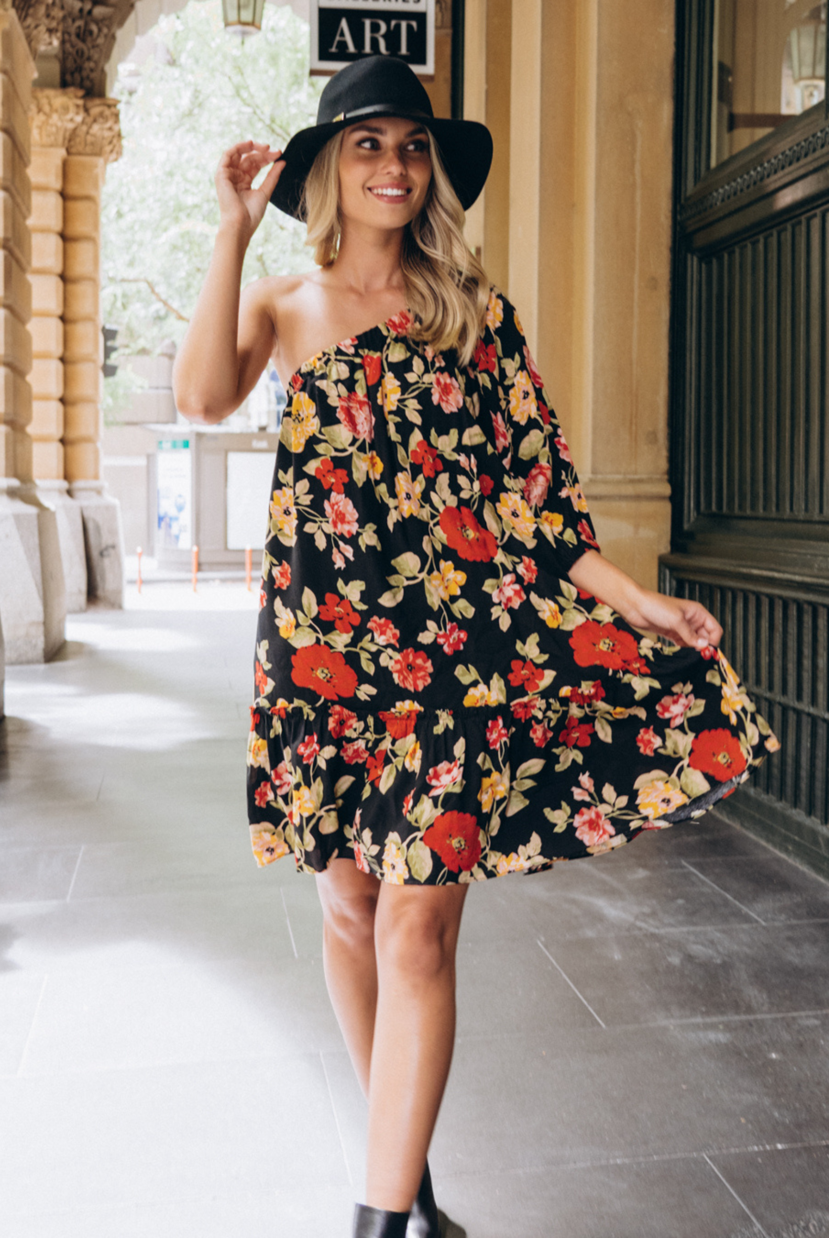 Model wearing the Josephina one shoulder dress in black base floral print