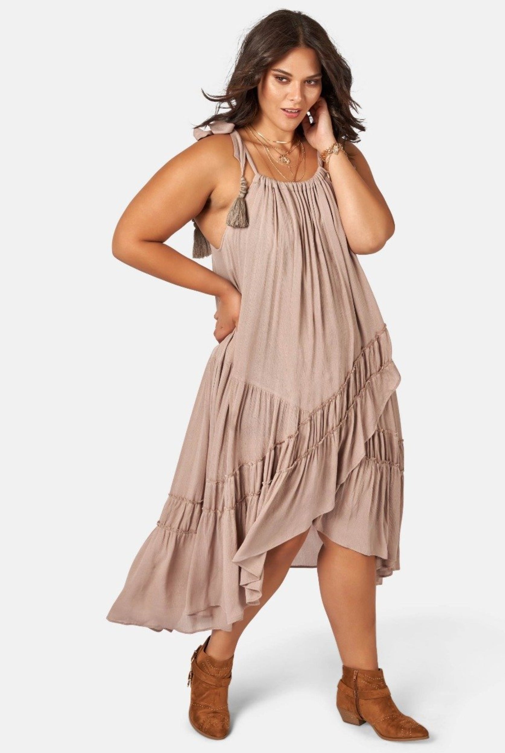 Model wearing nude maxi dress with asymmetric hemline