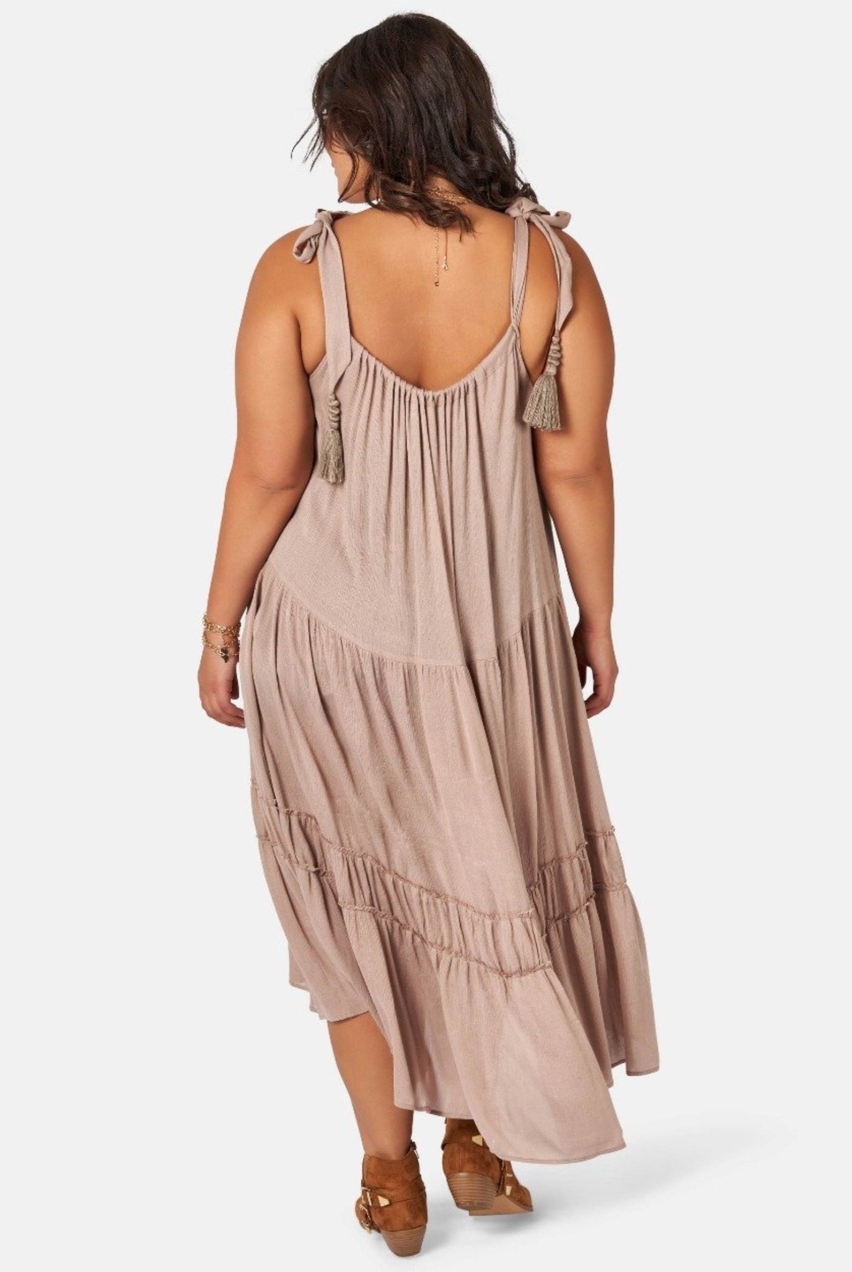 Model wearing nude maxi dress with asymmetric hemline