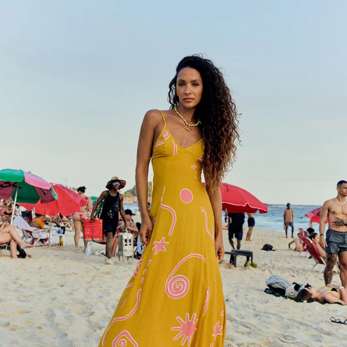 Model in a yellow printed Lokoa maxi dress on a beach