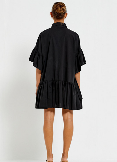 Model wearing the Bohemian Traders black Genoa Dress with button up front