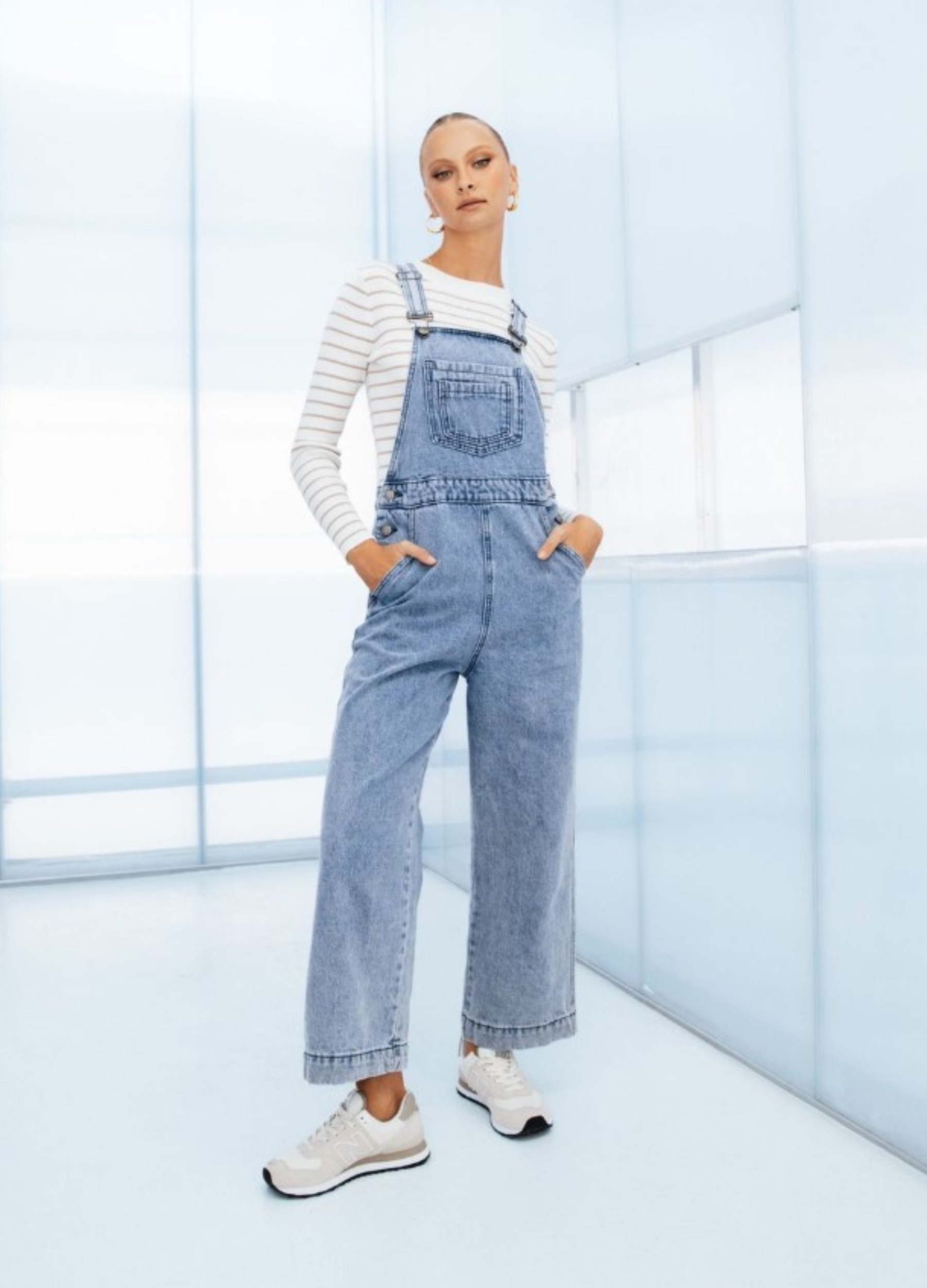 Model wearing lightwash denim overalls from paper heart