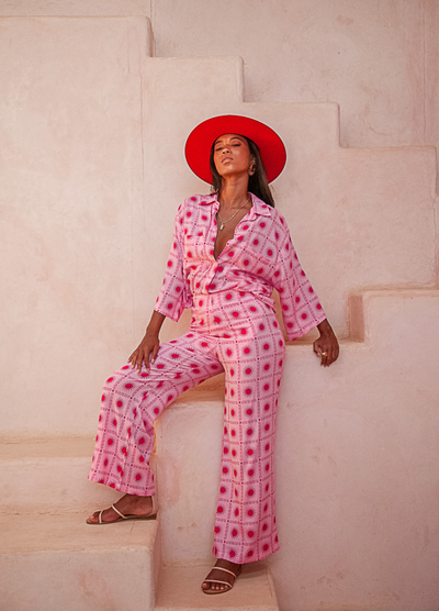 Model wearing the pink and red spanish sun blouse from Palm Collective