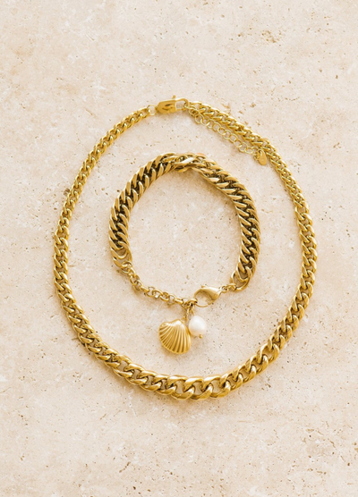 Gold chain link bracelet featuring a pearl and shell charm