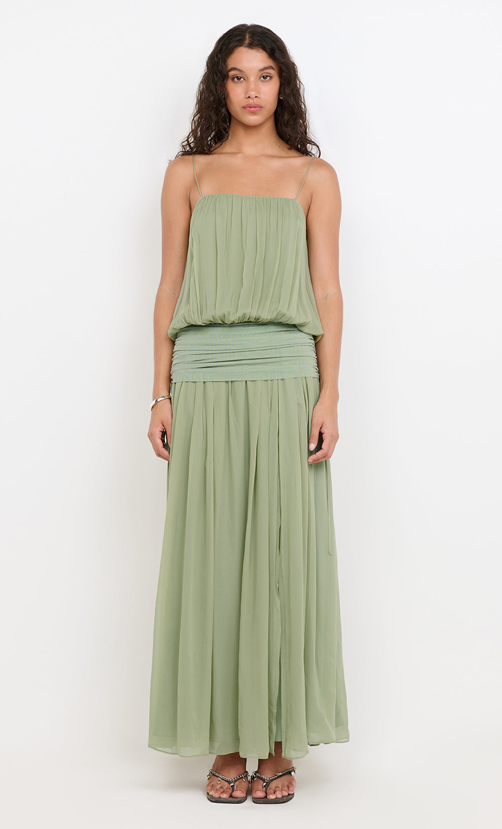 Woman wearing a green strapless dress on a white background