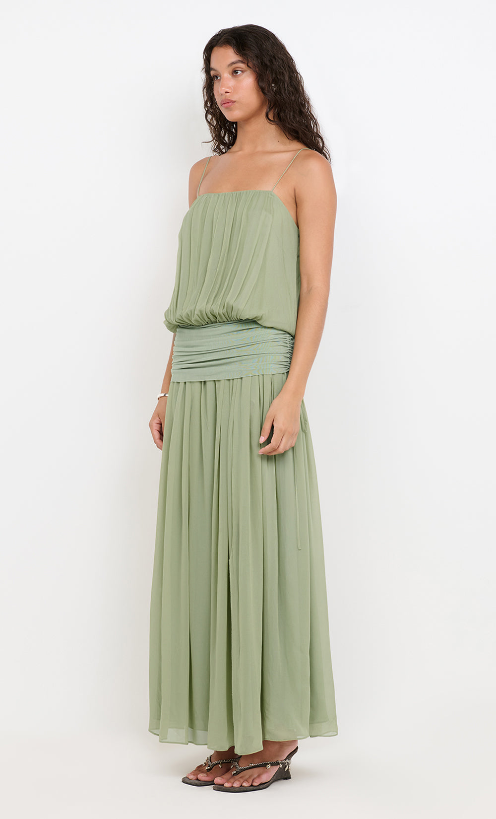 Woman wearing a green strapless dress on a white background