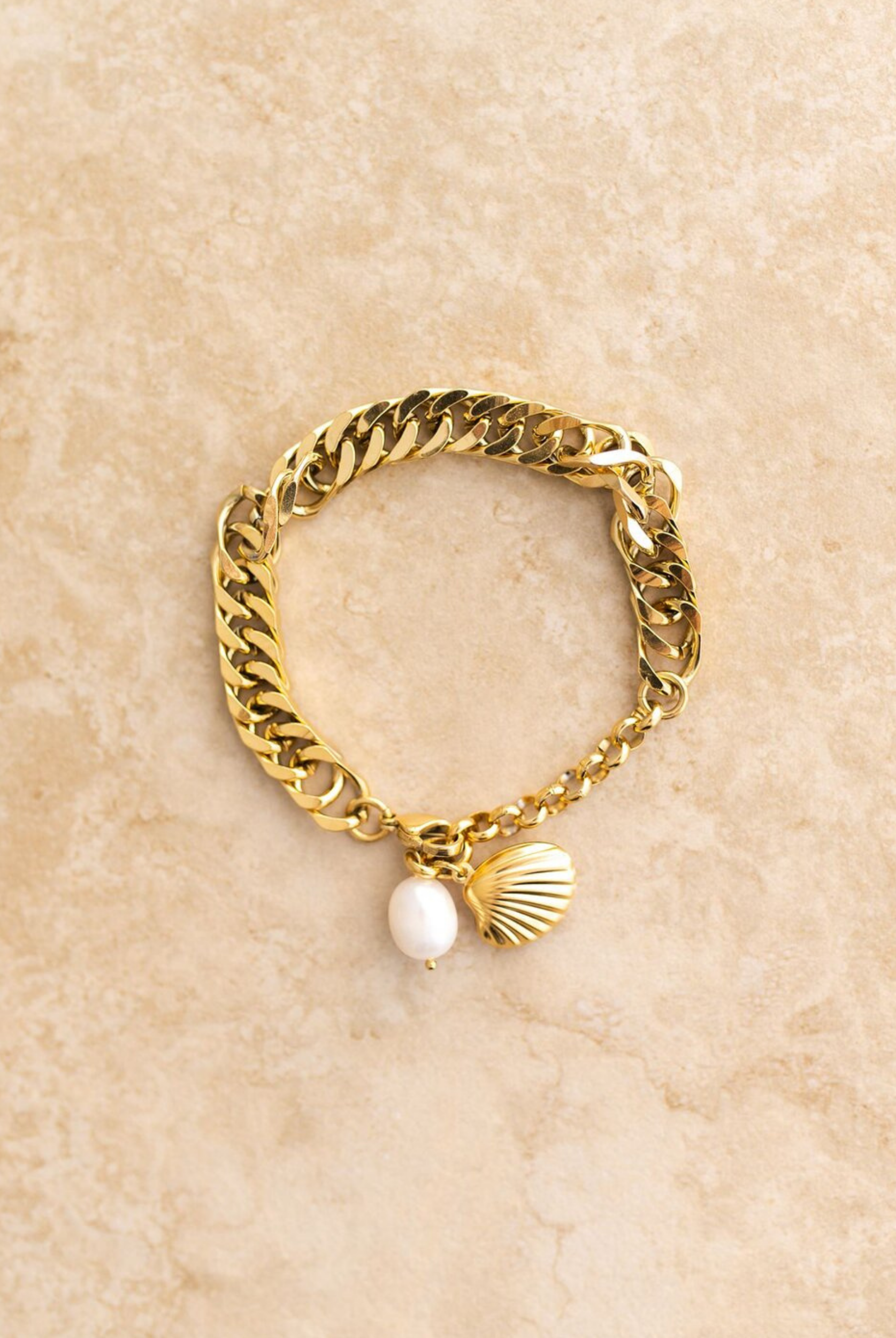 Gold chain link bracelet featuring a pearl and shell charm