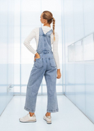 Model wearing lightwash denim overalls from paper heart