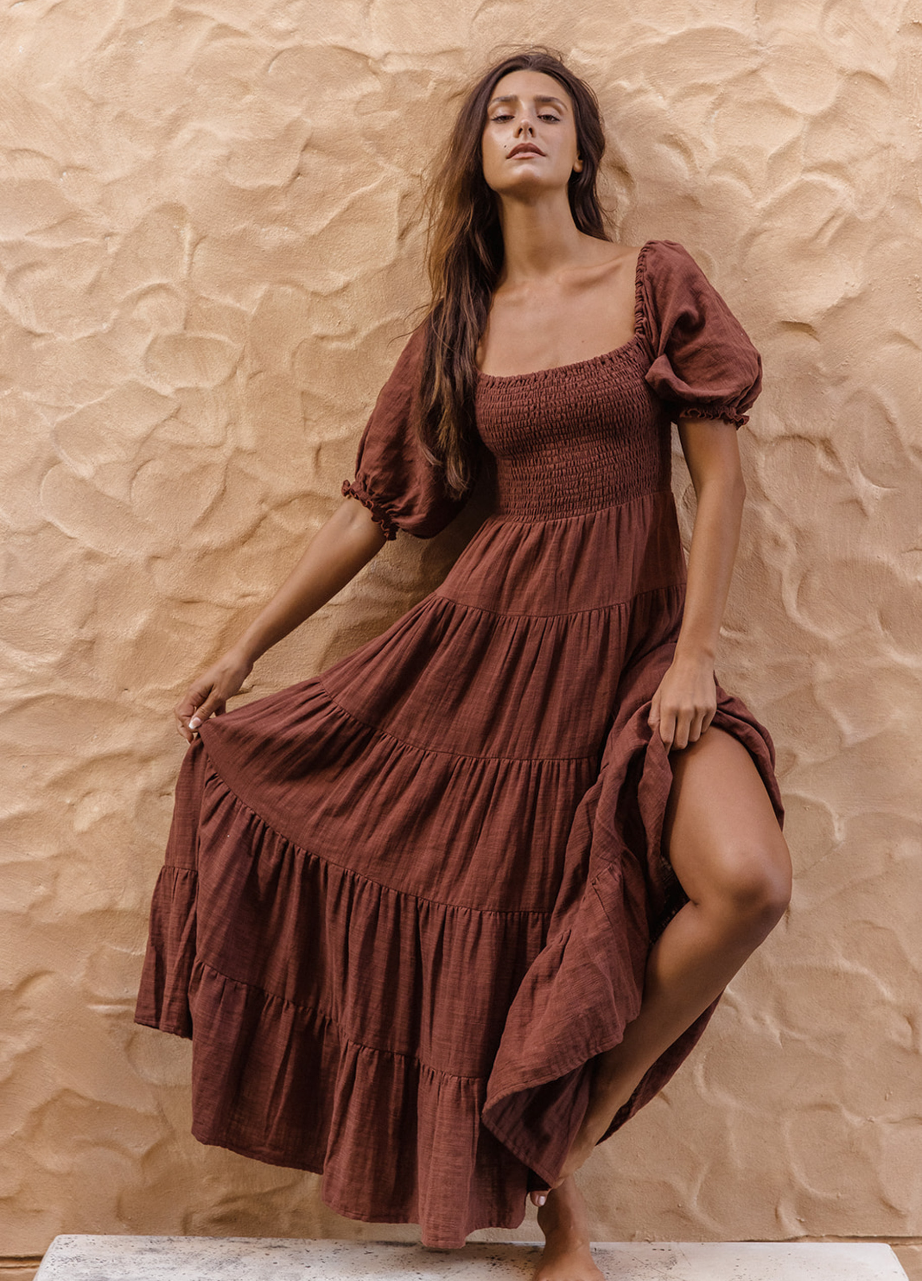 Model wearing chocolate brown tiered dress with short puffy sleeves