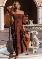 Model wearing chocolate brown tiered dress with short puffy sleeves