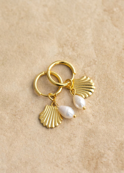 The Isla earrings have a gold shell design and a freshwater pearl