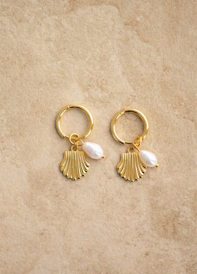 The Isla earrings have a gold shell design and a freshwater pearl