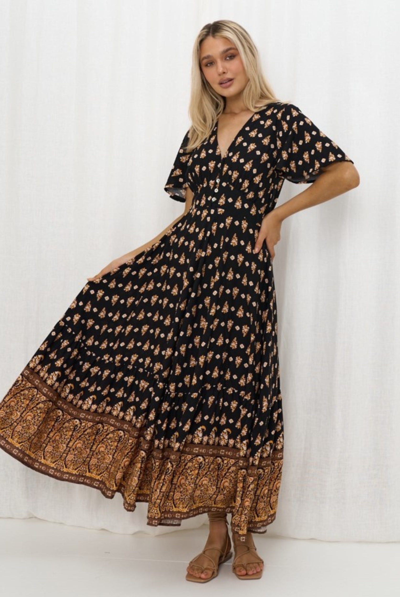 Model wearing the Iris Maxi Gypset Dress in black print with button front and cap sleeve