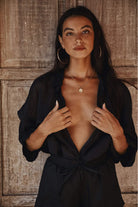 Woman wearing a black outfit with a textured wooden background