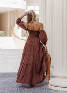 Model wearing chocolate brown tiered dress with short puffy sleeves