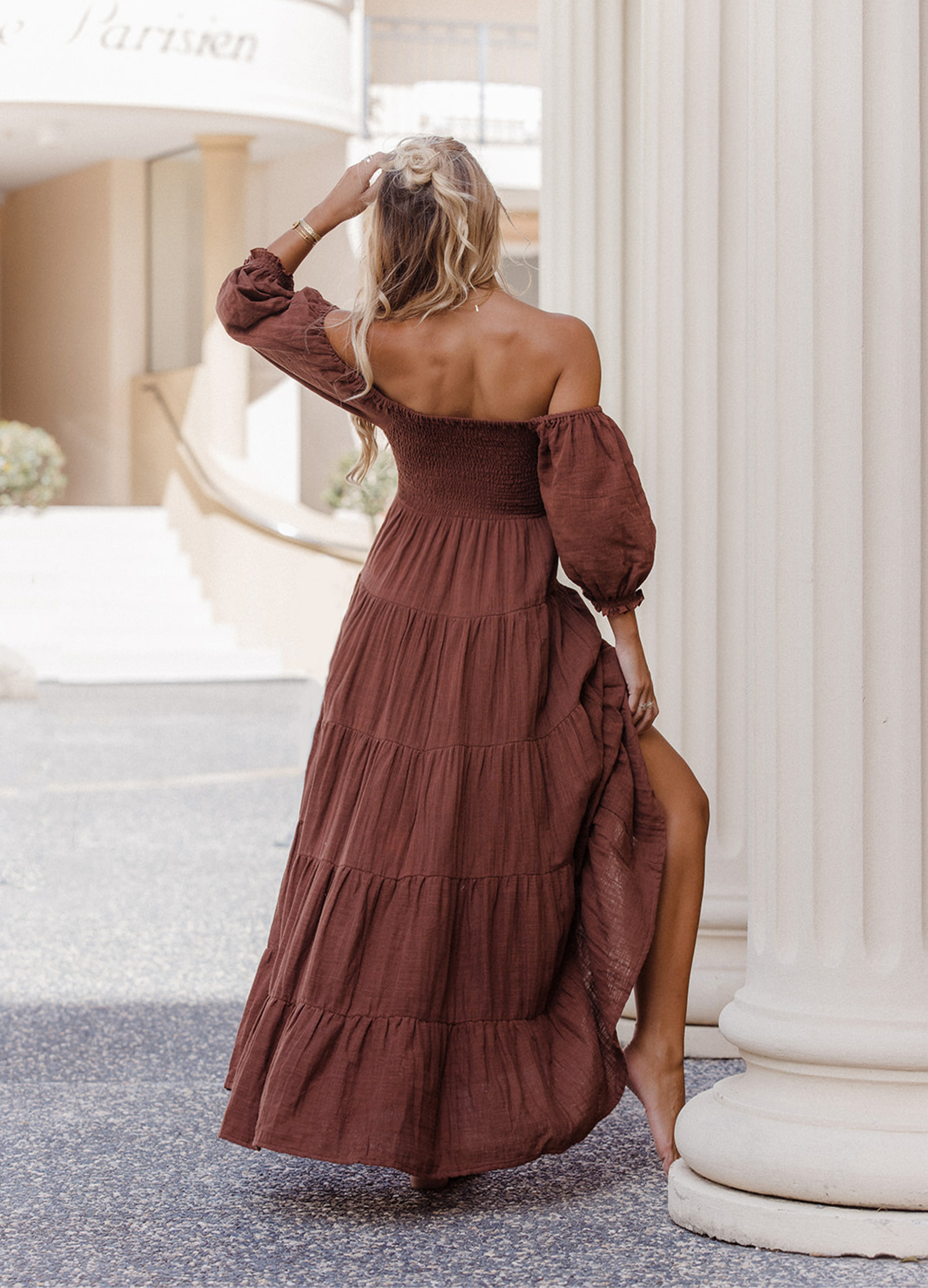 Model wearing chocolate brown tiered dress with short puffy sleeves