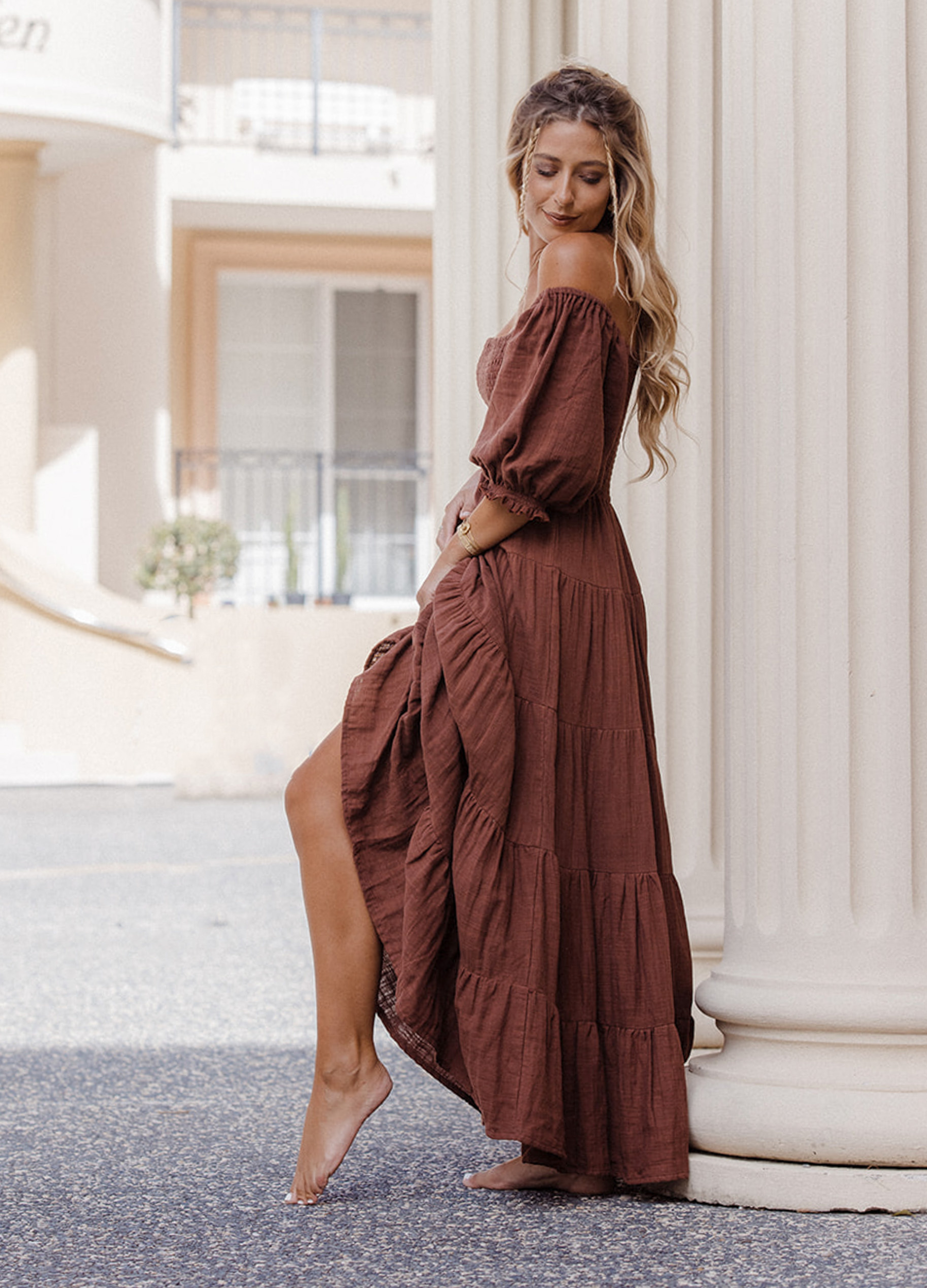 Model wearing chocolate brown tiered dress with short puffy sleeves