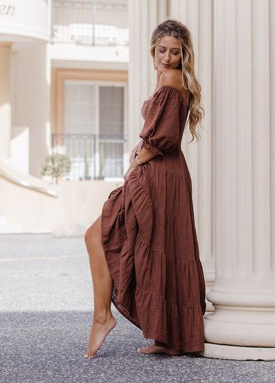 Model wearing chocolate brown tiered dress with short puffy sleeves