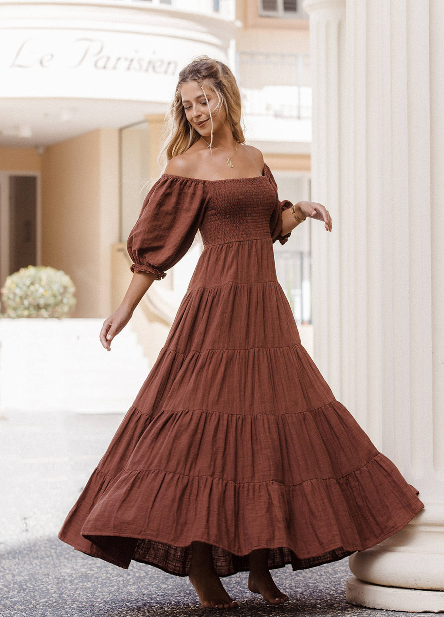 Model wearing chocolate brown tiered dress with short puffy sleeves