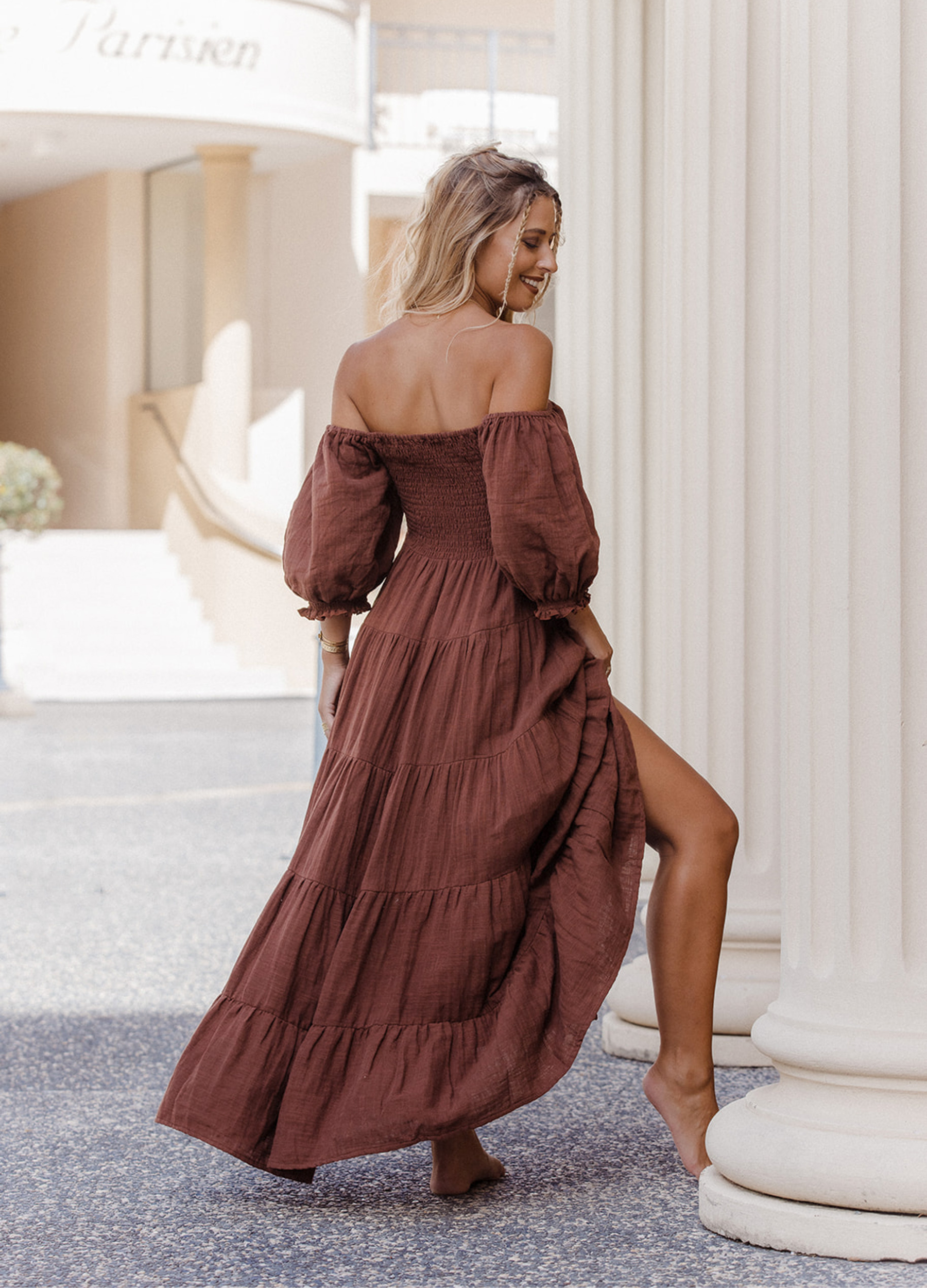 Model wearing chocolate brown tiered dress with short puffy sleeves