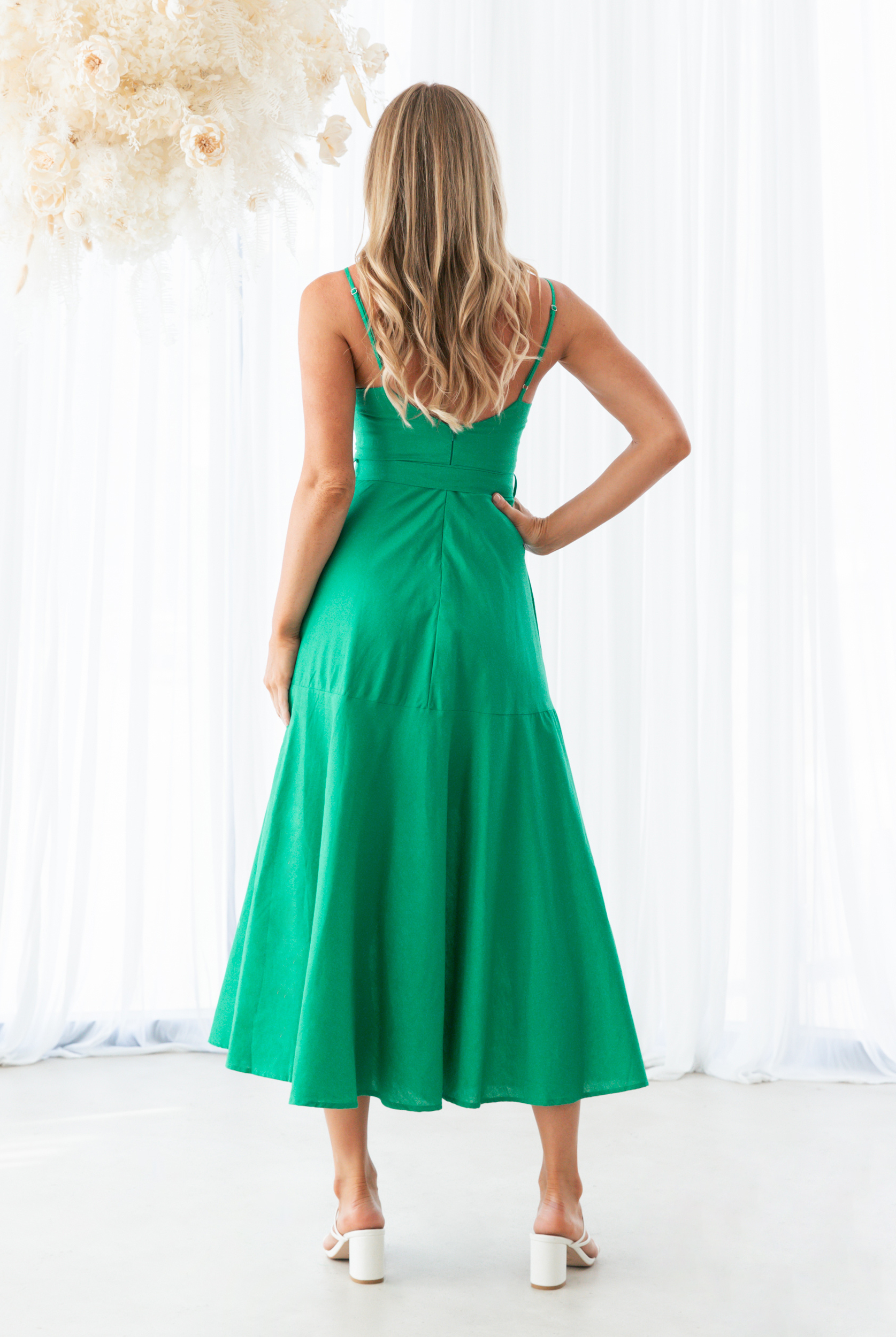 Festive green christmas dress with straps and bow detail at waist