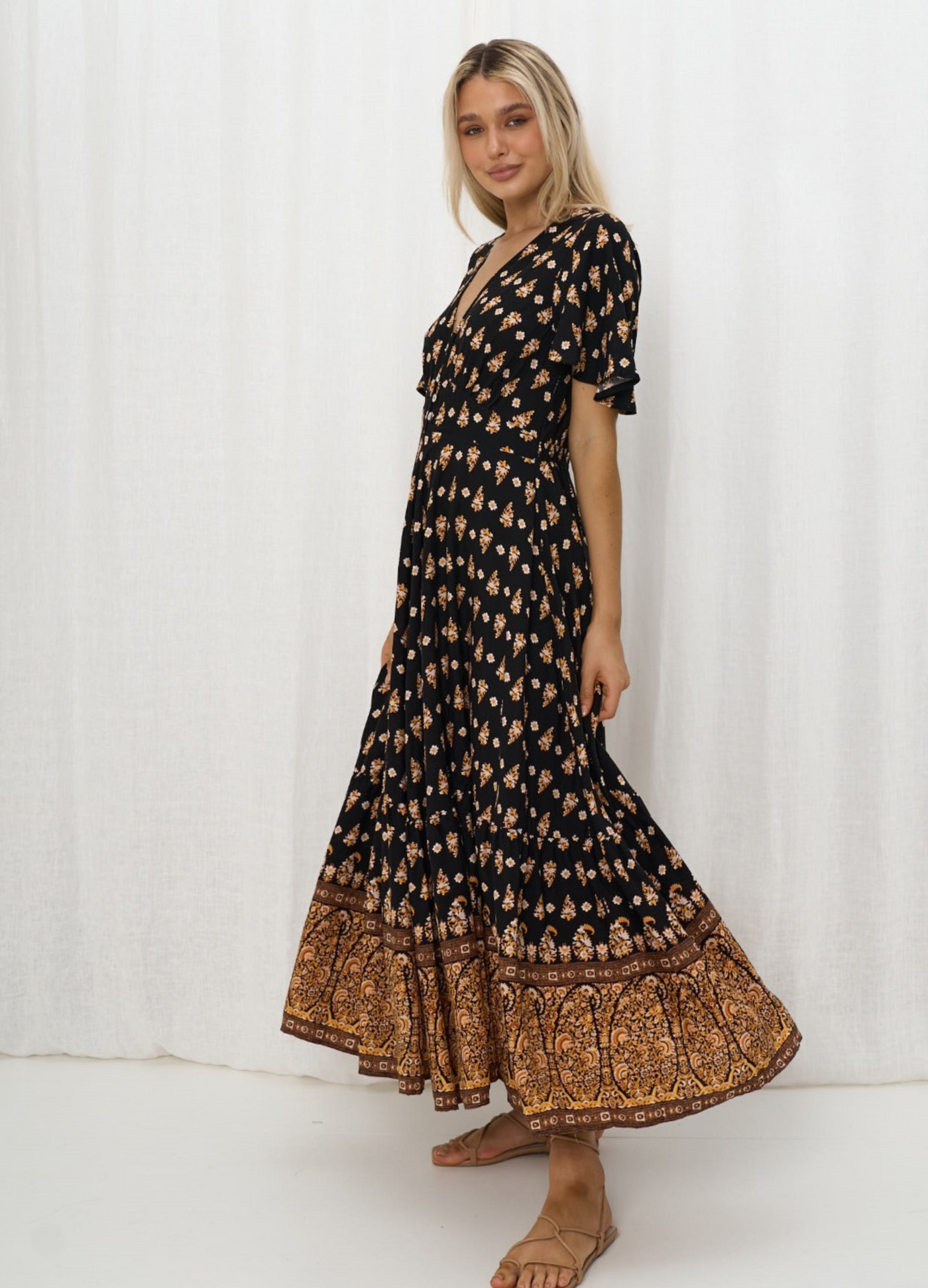 Model wearing the Iris Maxi Gypset Dress in black print with button front and cap sleeve